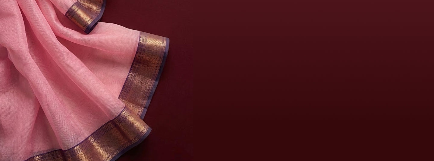 Pink saree with metallic woven border draped against a maroon background