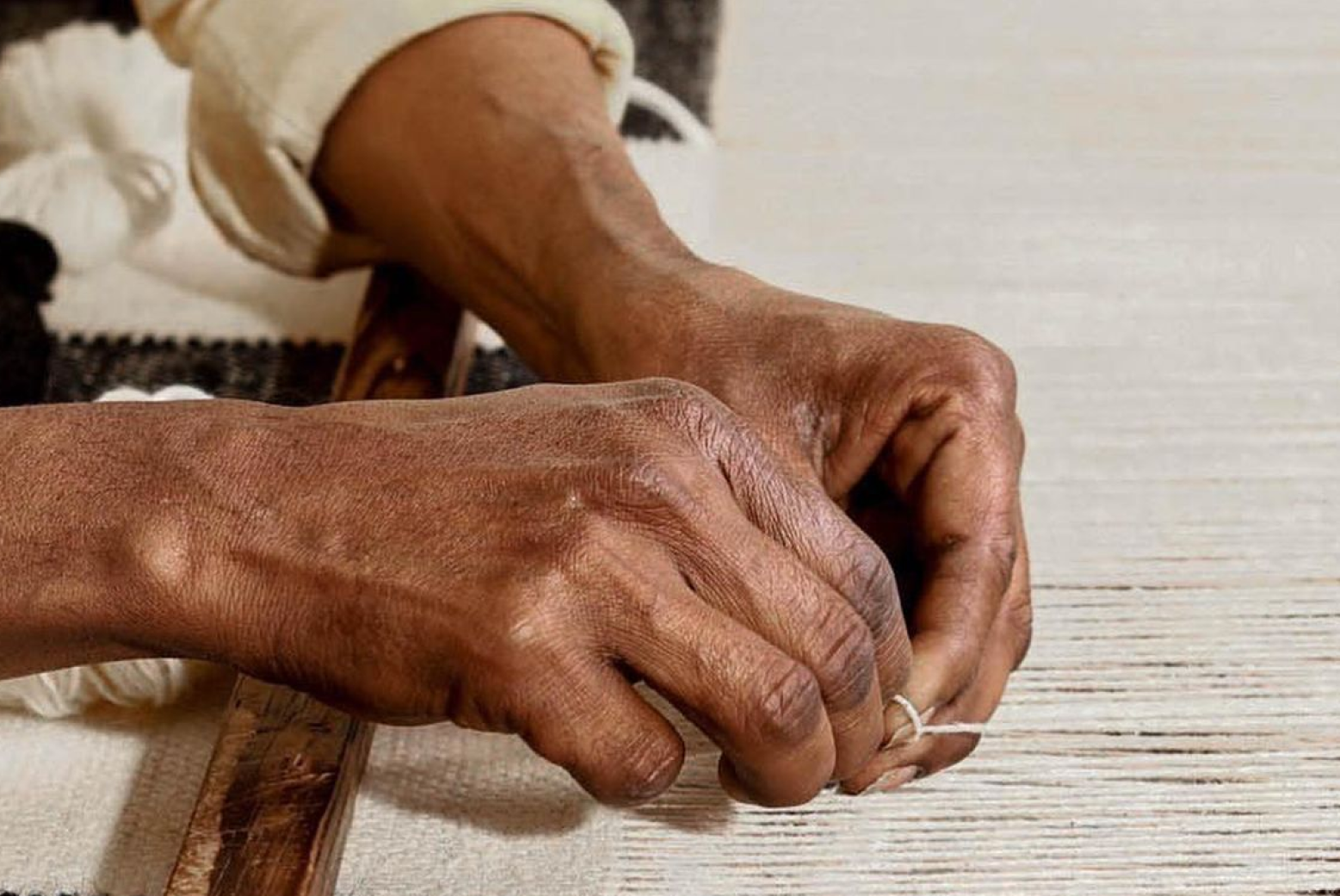 Artisan arranging warp threads during traditional handloom setup